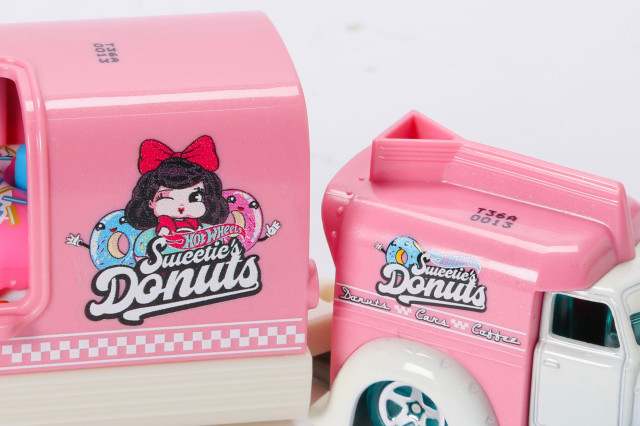 A close of a pink hot wheels rig shows a logo of a lady with brown hair and a red bow