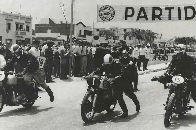 Three riders jump onto their motorcycles at the start of a race.