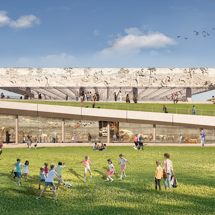 Groups of visitors gathered on a grass lawn in front of a glass wall with skeletons behind it and a ramp in the distance